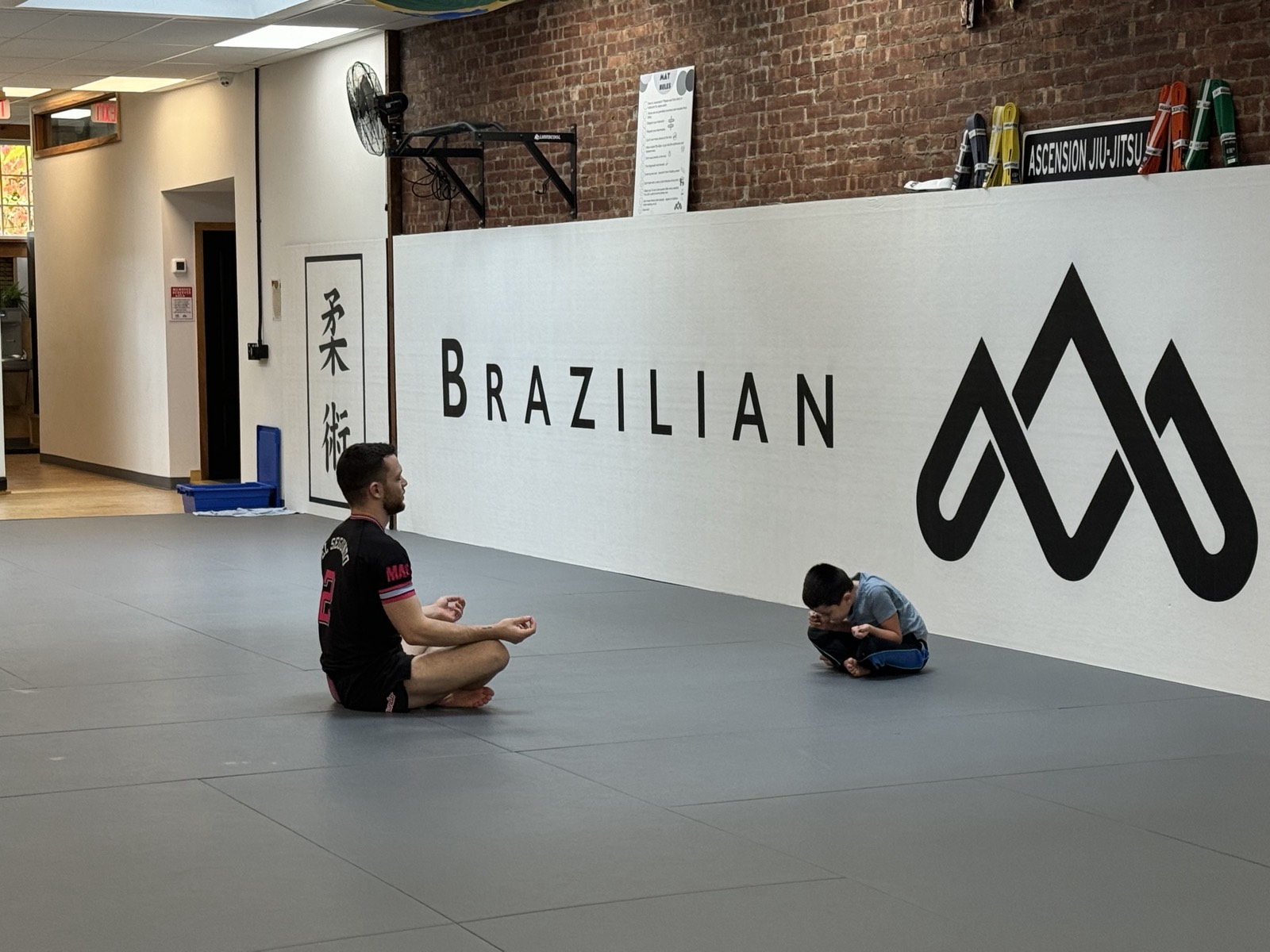 Chris and a young student practicing mindfulness on the mats